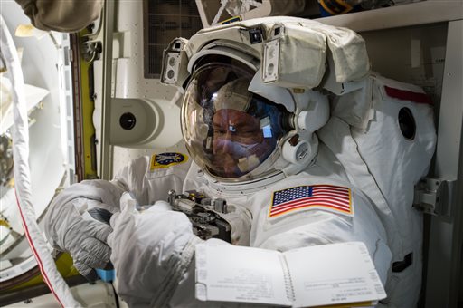 In this photo provided by NASA and posted on Twitter on Oct. 26, 2015, astronaut Scott Kelly tries on his spacesuit inside the U.S. Quest airlock of the International Space Station. NASA opened its astronaut-application website Monday, Dec. 14, 2015. It's accepting applications through Feb. 18, 2016. 