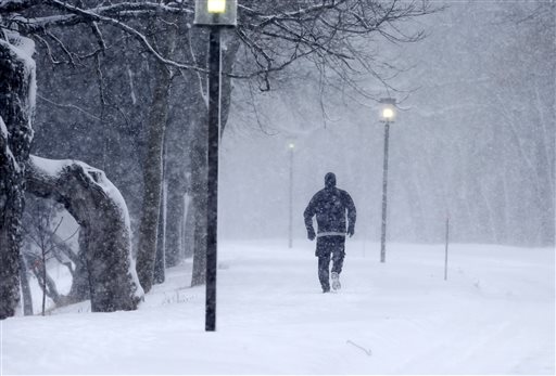 Street lights are illuminated as a jogger runs around Lake Harriet, Tuesday, Feb. 2, 2016. (AP Photo/Jim Mone)