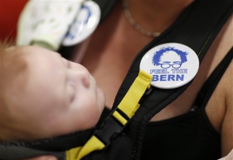 A woman wears a pin while holding her child before a rally with Democratic presidential candidate, Sen. Bernie Sanders, I-Vt., Monday, March 21, 2016, in Salt Lake City. (AP Photo/John Locher)