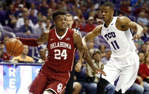 Oklahoma guard Buddy Hield (24) looks to pass as TCU guard Brandon Parrish (11) defends during the first half of an NCAA college basketball game in Fort Worth, Texas.