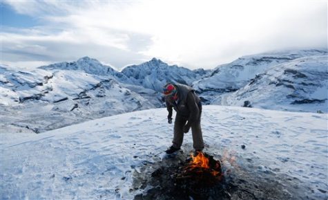 Aymara priest Valentin Apaza stands over a burning offering for the "Pachamama," or Mother Earth, during a ceremony on La Cumbre, a mountain considered sacred ground on the outskirts of La Paz, Bolivia, Wednesday, April 22, 2015. (AP Photo/Juan Karita)