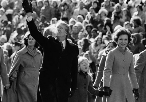 President Jimmy Carter and first lady Rosalynn Carter have one hand for the crowd along Pennsylvania Avenue and one for their daughter Amy. The Carters elected to walk the parade route from the Capitol to the White House following his inauguration in Washington, on Thursday, Jan. 20, 1977.