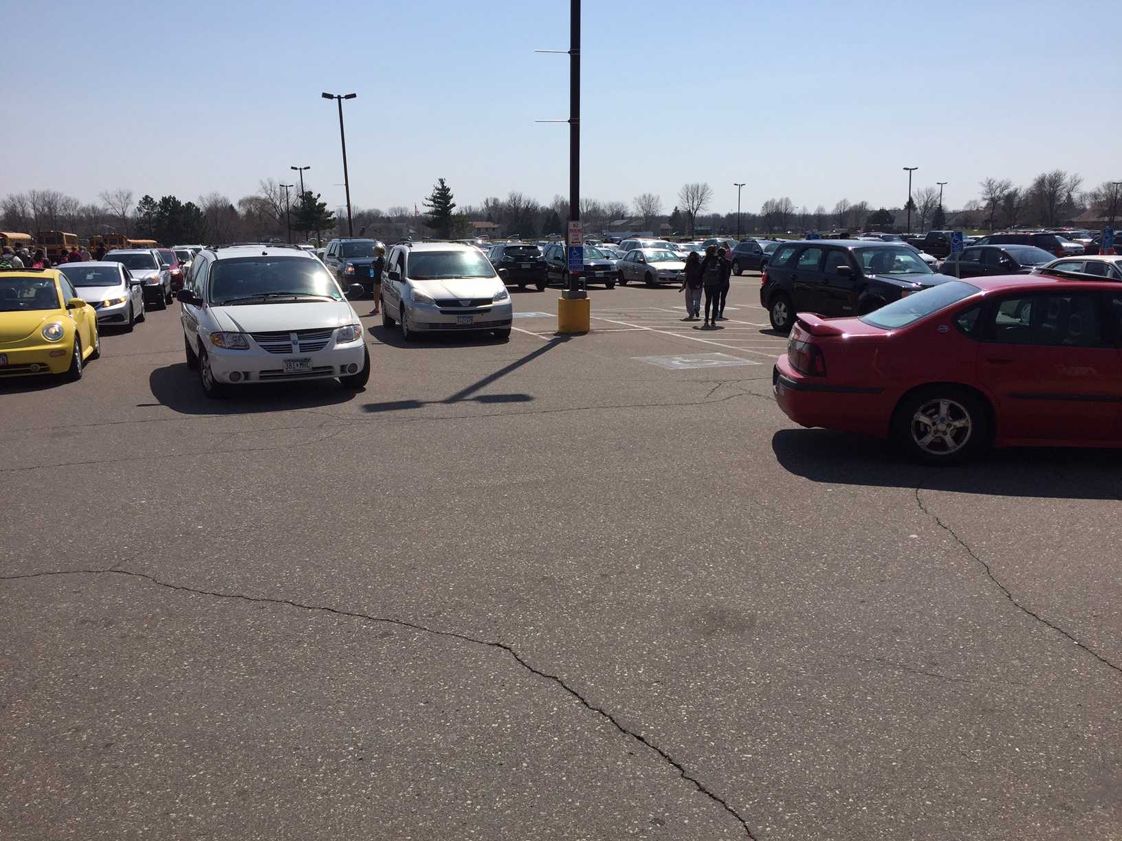 Students, staff, and parents flood the parking lot at 2:20.