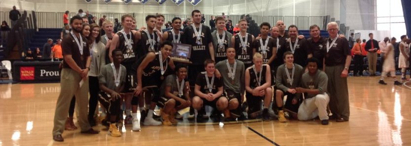 The boys basketball team celebrating with their new hardware