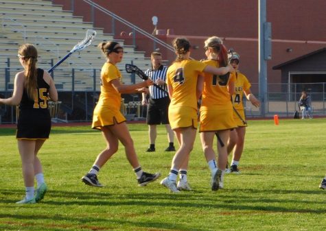 Fellow teammates celebrate after midfielder Rachel Hertzberg scores in the second half.