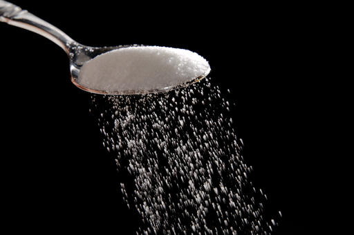 Granulated sugar is poured in Philadelphia, Monday, Sept. 12, 2016. A new study released Monday details how the sugar industry worked to downplay emerging science linking sugar and heart disease.