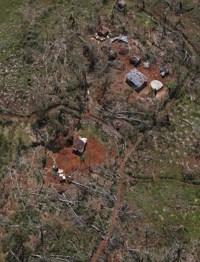 In this Oct. 13, 2016 photo, fallen trees are scattered around homes damaged and destroyed by Hurricane Matthew in the mountains of southwestern Haiti. Haitian and international agricultural officials say it could be a decade or more before the southwestern peninsula recovers economically from Hurricane Matthew, which struck hard at the rugged region of more than 1 million people that is almost completely dependent on farming and fishing. (AP Photo/Rebecca Blackwell)