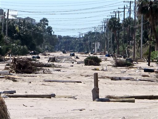 Debris from the storm surge of Hurricane Matthew litters the ocean front street in Edisto Beach, S.C., on Monday, Oct. 10, 2016. Town officials say the storm washed between 3 and 4 feet of sand onto the street and the community took its worst hurricane hit since Hurricane David back in 1979. (AP Photo/Bruce Smith)