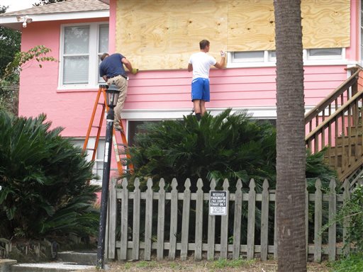 Workers hammer plywood over the windows of a home in Folly Beach. S.C., on Wednesday, Oct. 5, 2016. The winds and rains of Hurricane Matthew are expected to affect the South Carolina coast by late in the week. (AP Photo/Bruce Smith)