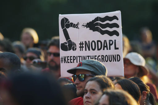 A protester holds up a placard against the construction of the Dakota Access oil pipeline on the Standing Rock Reservation.