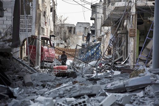 In this Nov. 19, 2014 photo, a young Kurdish YPG fighter runs past sniper fire in the contested zone in Kobani, Syria, the site of fighting between the Kurds and Islamic State militants. (AP Photo/Jake, Simkin)