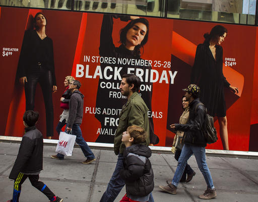 Shoppers pass by a retail store as they walk along Fifth Avenue on Black Friday in New York, Friday, Nov. 25, 2016. Shoppers were on the hunt for deals Friday as malls opened for what is still one of the busiest days of the year, even as the start of the holiday season edges ever earlier. (AP Photo/Andres Kudacki)