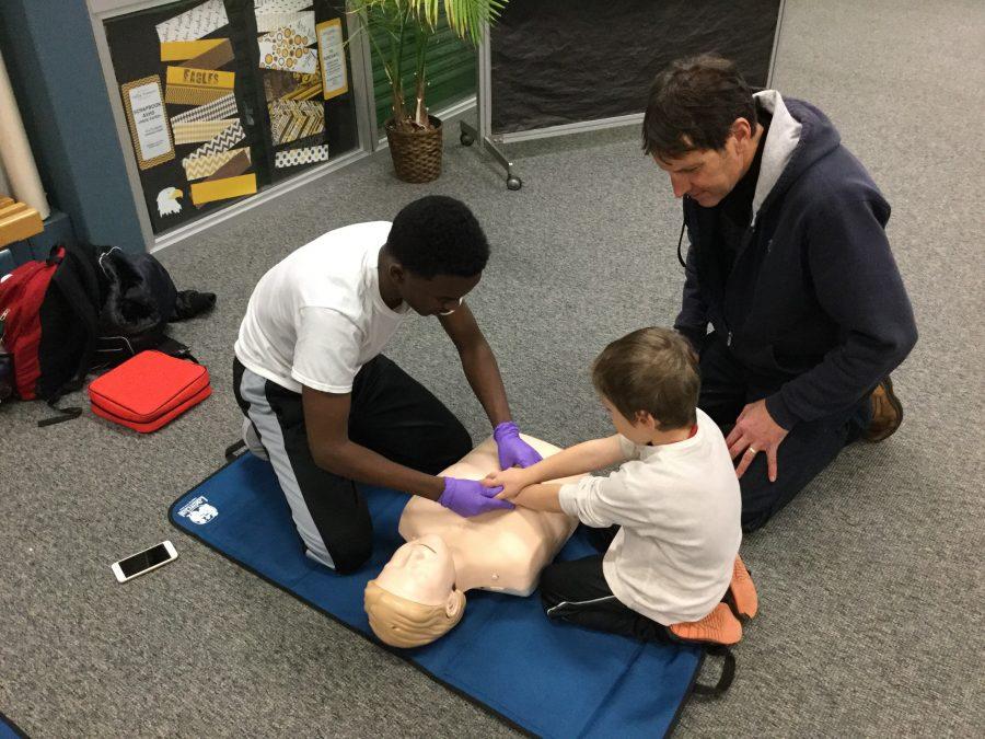 Sophomore Ayanle Issak, part of the Inver Hills EMR class, leads a CPR activity.