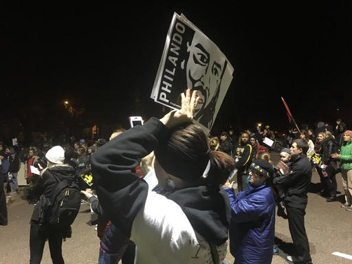 A woman holds a sign with Philando Castile's image during a rally in St. Paul, Minn., after a police officer is charged in Castile's fatal shooting in Falcon Heights, Wednesday, Nov. 16, 2016.  (AP Photo/Jeff Baenen)