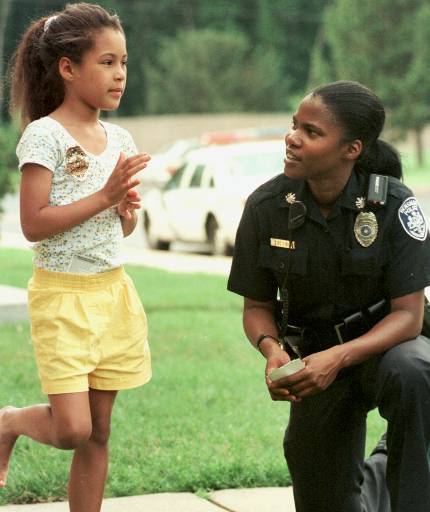 Community police officer Theresa Nelson has a chat with Victoria McDaniel while Pennsylvania communities' attempt to expand their police force. (AP Photo/Tim Shaffer)