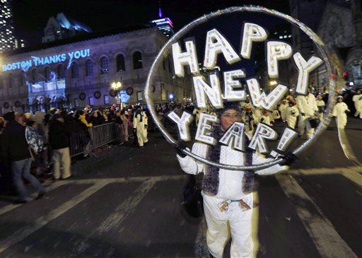 File-This Dec. 31, 2013, file photo shows marchers making their way down Boylston Street during a parade as part of New Year's Eve celebrations in Boston.