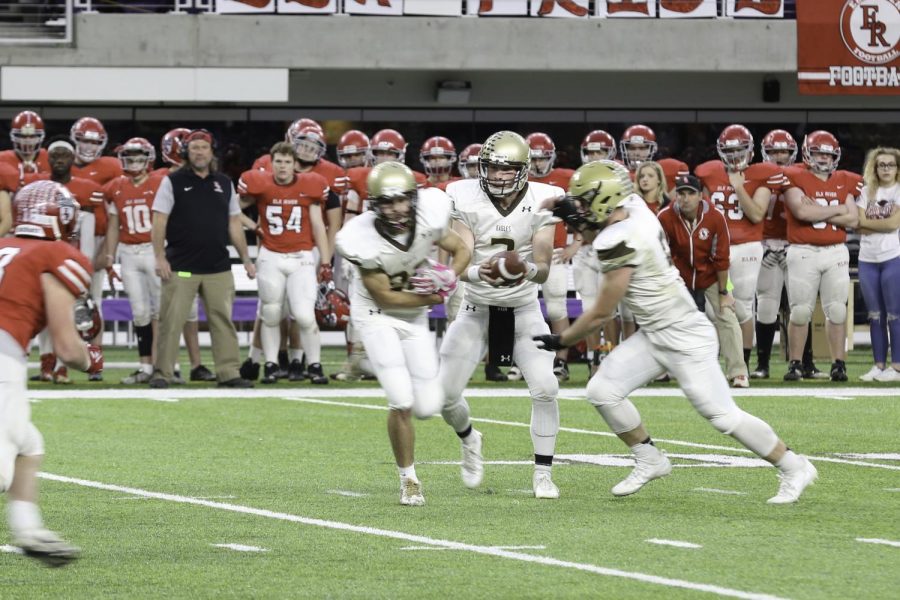 Quarterback Tyler Cardella (senior) hands off to a back.